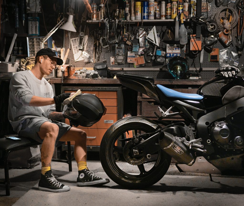 uomo che pulisce casco con moto