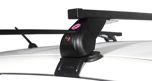 Barra portatutto Modula nera compatta montata sul tetto di un’auto bianca con piede di fissaggio e supporto per trasporto.